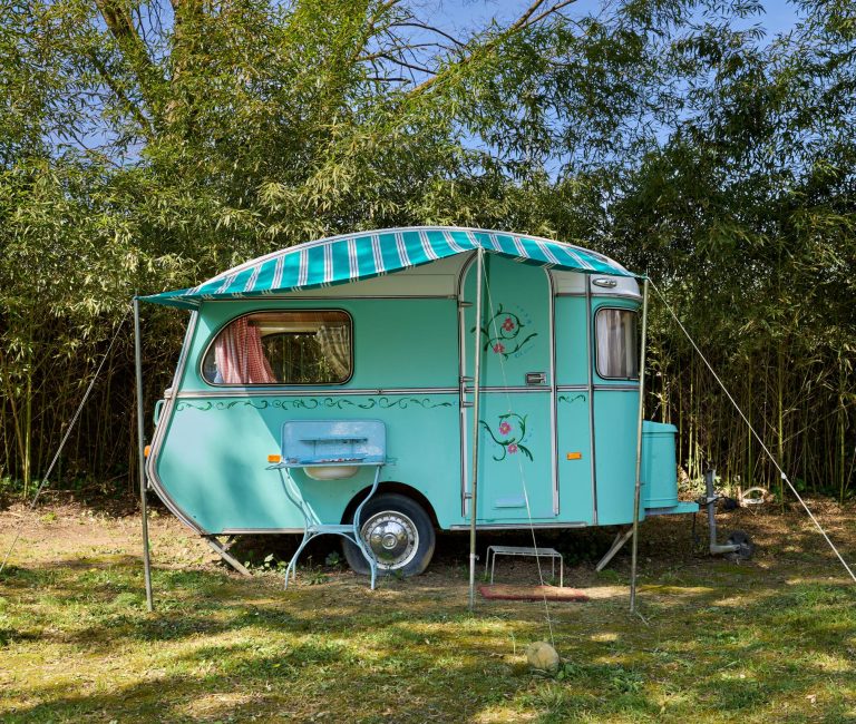 Vintage blauwe caravan van Blauwe Weide in de tuin van 123 Olé