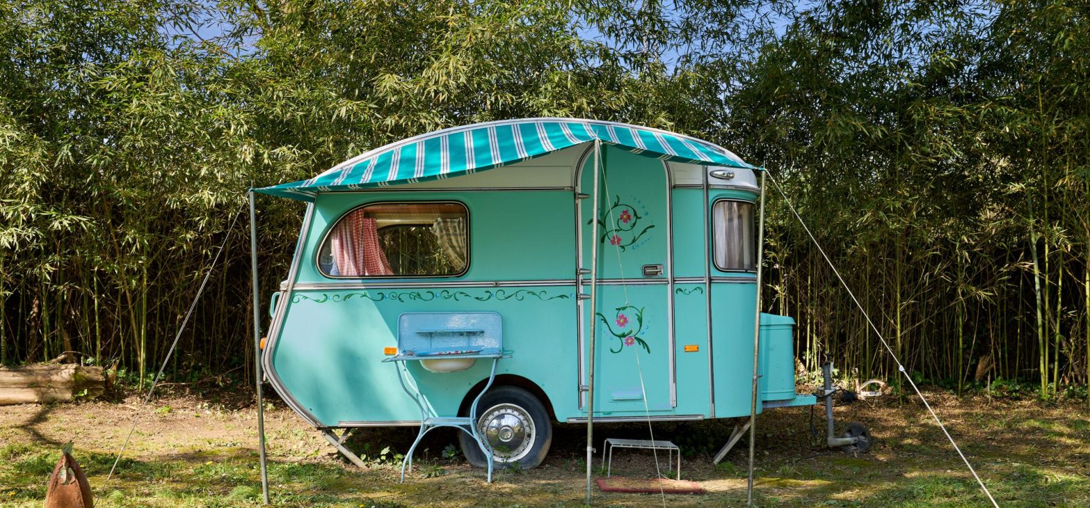 Vintage blauwe caravan van Blauwe Weide in de tuin van 123 Olé